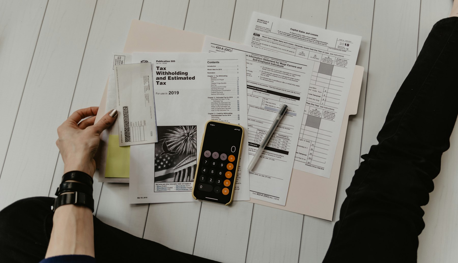 Financial paperwork and a calculator laid out on a desk, seen from above.