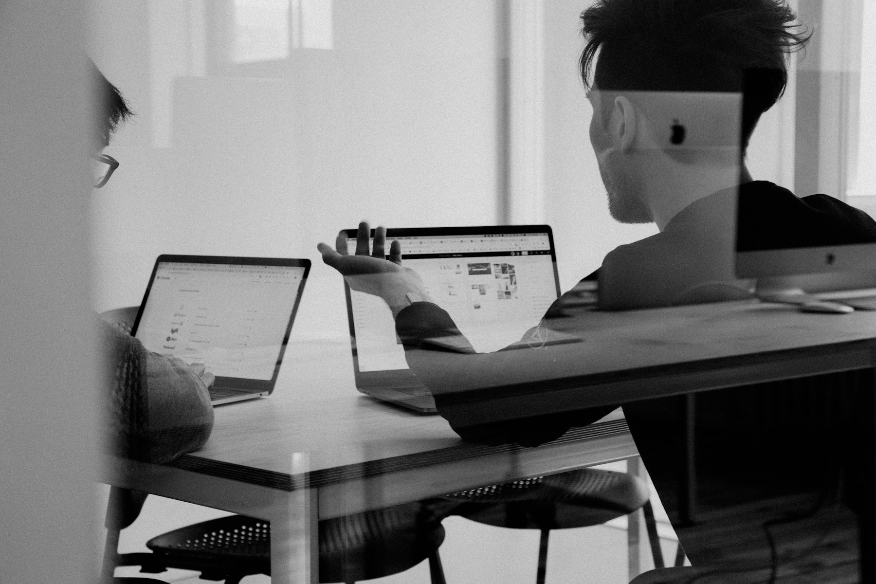 A team working together at laptops in a meeting room.